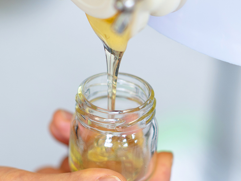 岩手県産の生はちみつを瓶にゆっくり注いでいる様子