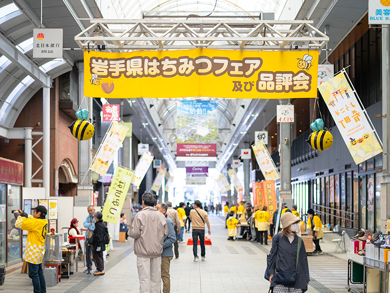 岩手県はちみつフェアの入口とにぎわう肴町商店街の様子