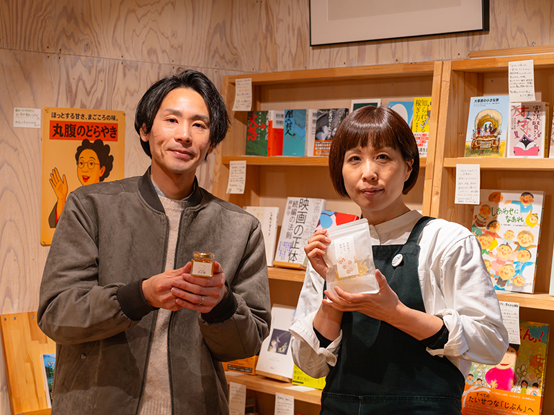 書肆みず盛り店内で、阿部商店2に参加するモカメルの商品を手にする様子