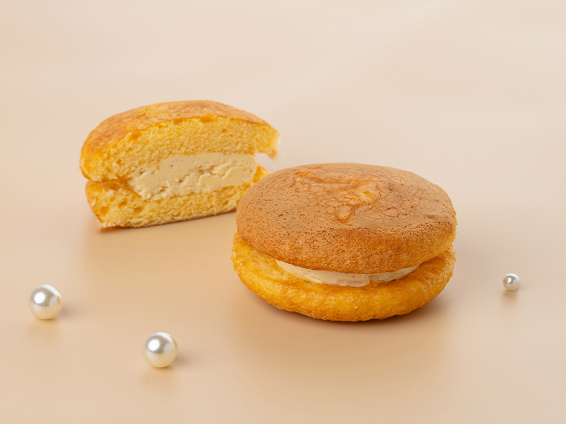 ふんわりとした生地で特製チーズクリームをサンドしたハニーチーズブッセと、その断面