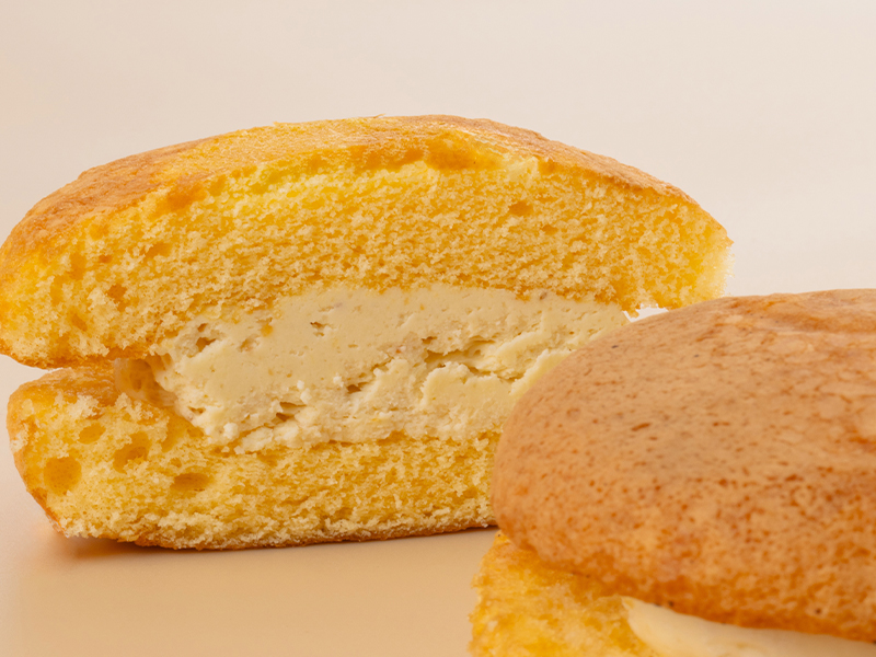 ハニーチーズブッセの柔らかな焼き生地と、たっぷり詰まったなめらかなチーズクリームの断面アップ